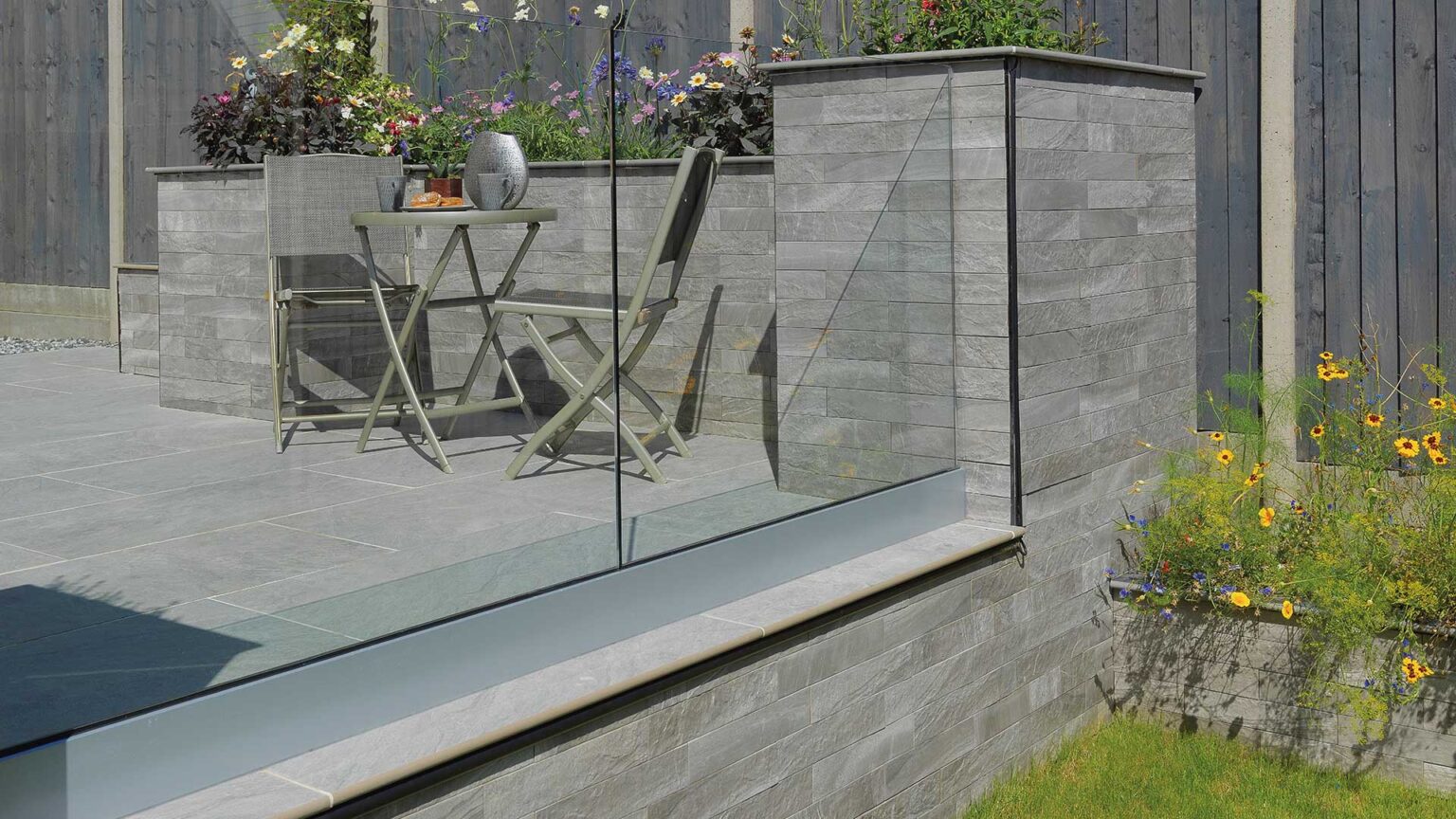 Stone-effect porcelain slip cladding used here on this patio's terrace and parapet walls.