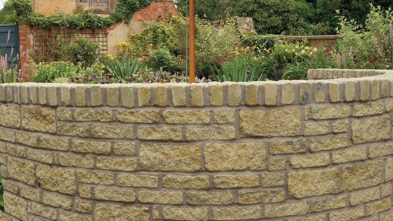 Reconstituted stone wall with tumbled block in a range of different sizes.