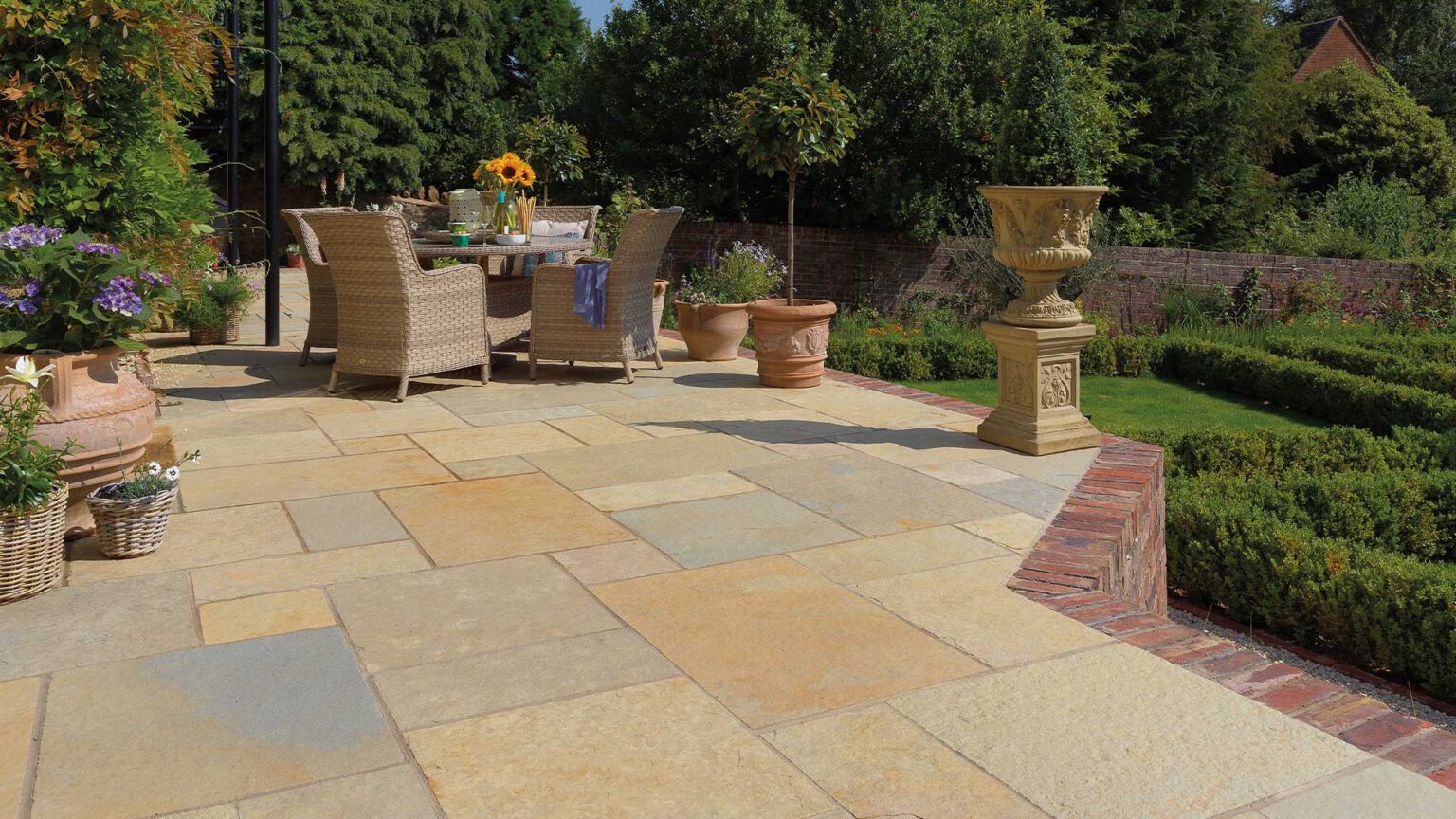 Traditional red brick retaining wall on this terrace with solidier course edging sitting flush with the limestone paving deck.