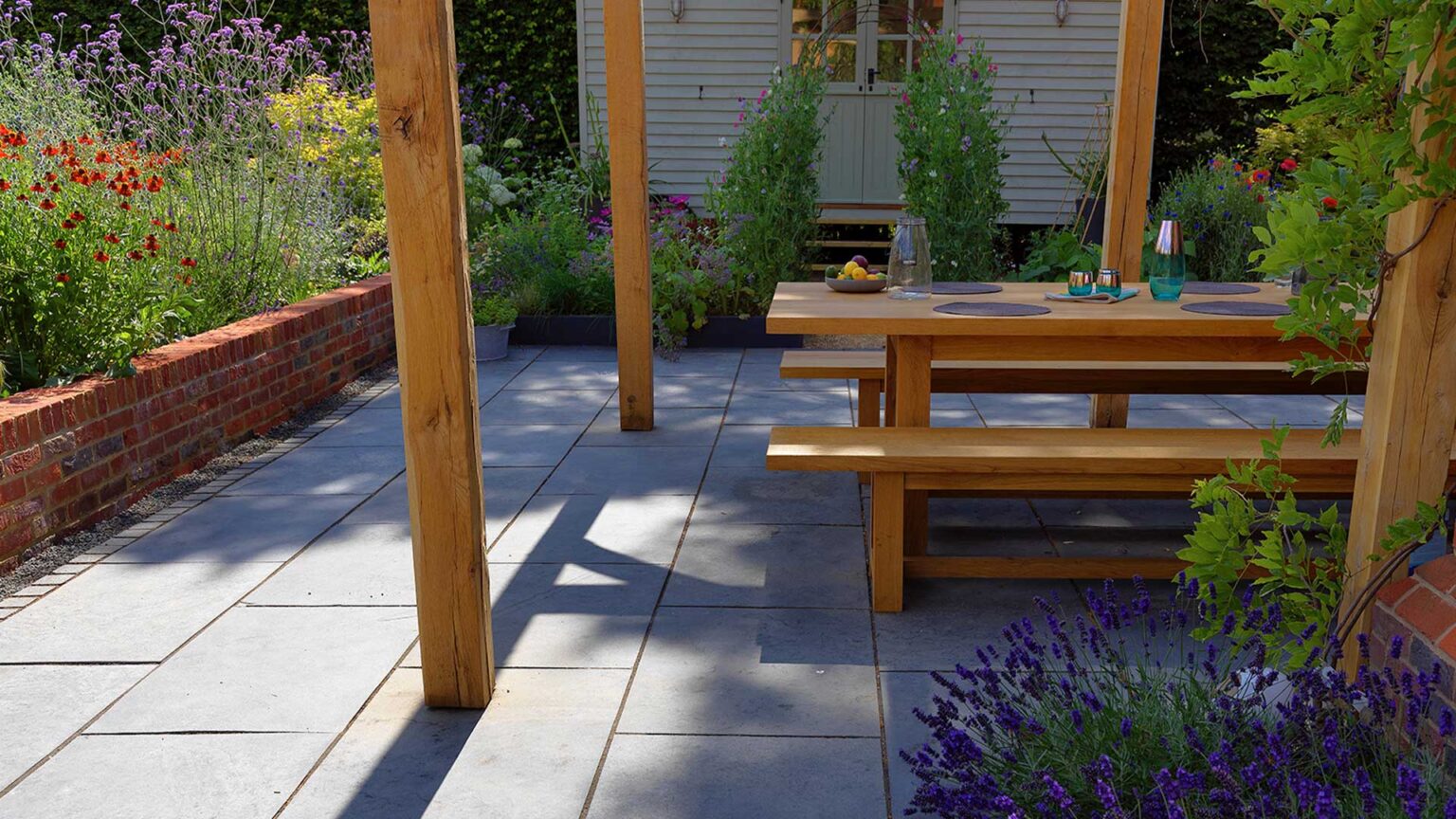 A red brick parapet knee wall with brick soldier course separating the patio and garden border