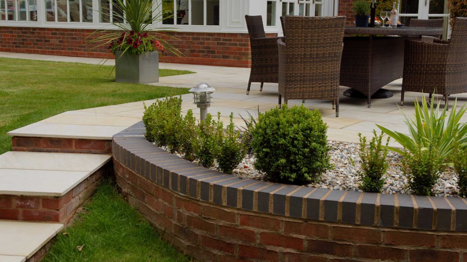 A brick knee wall retaining a terrace and raised bed.