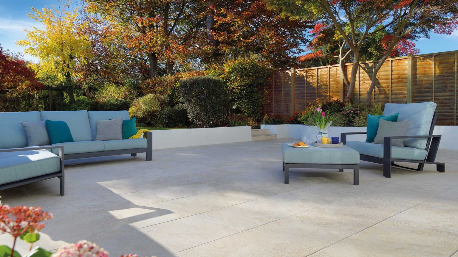 A simple white rendered retaining wall is used on this garden terrace to create a clean and elegant frame to the patio.