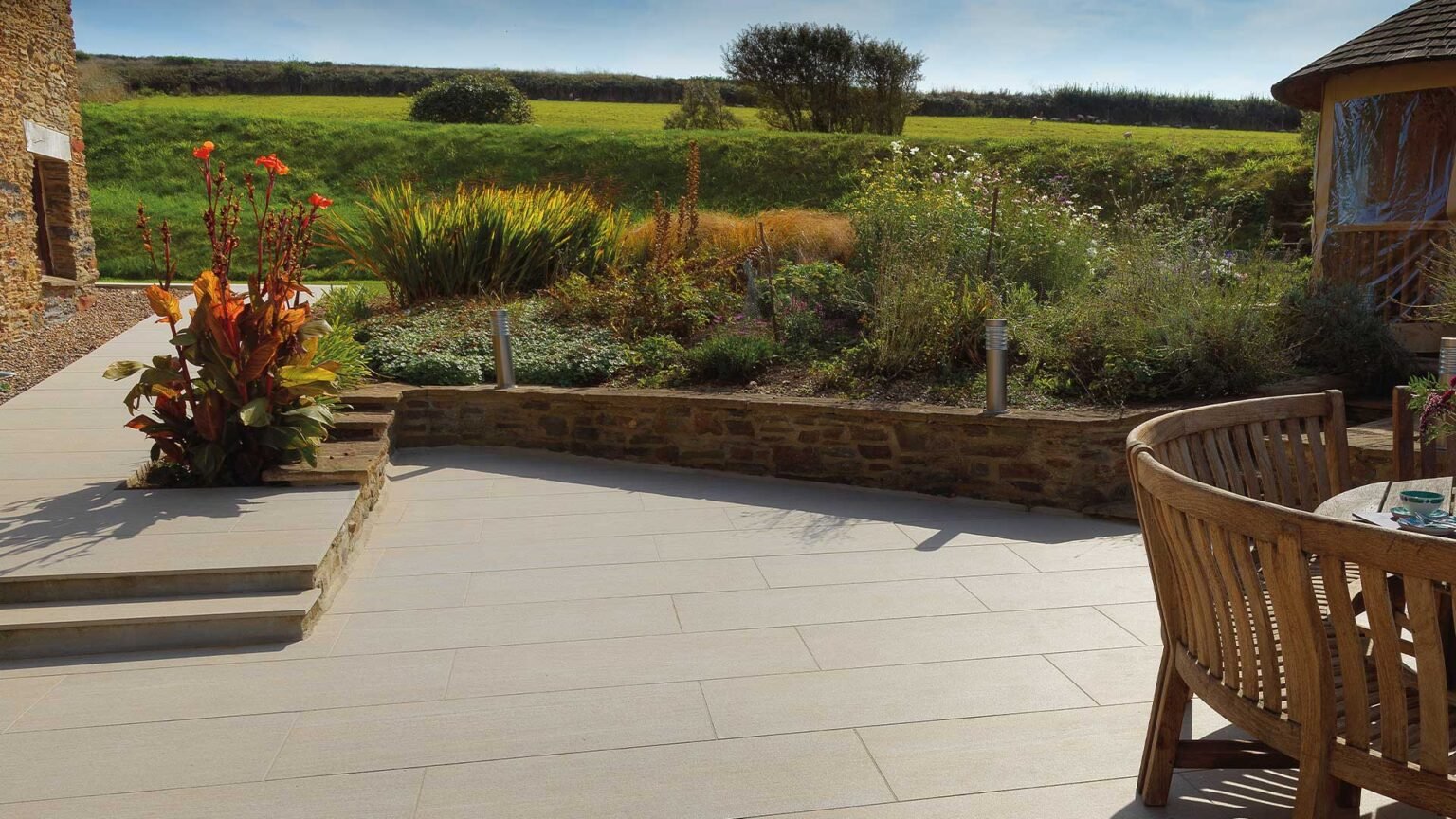 Bonded low sandstone retaining wall with coping stones for the raised beds and steps.