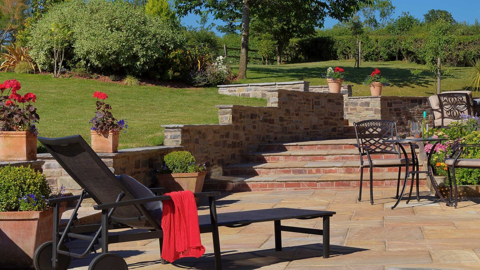 A bonded sandstone dwarf wall with elevation changes retaining this terraced patio