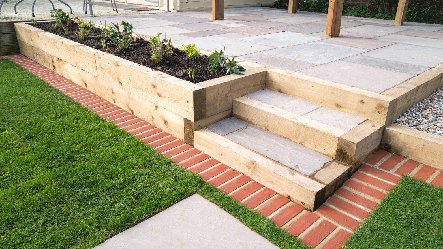 A contemporary style terrace using timber for the raised beds, step risers and stringers, and also for the retaining wall face.