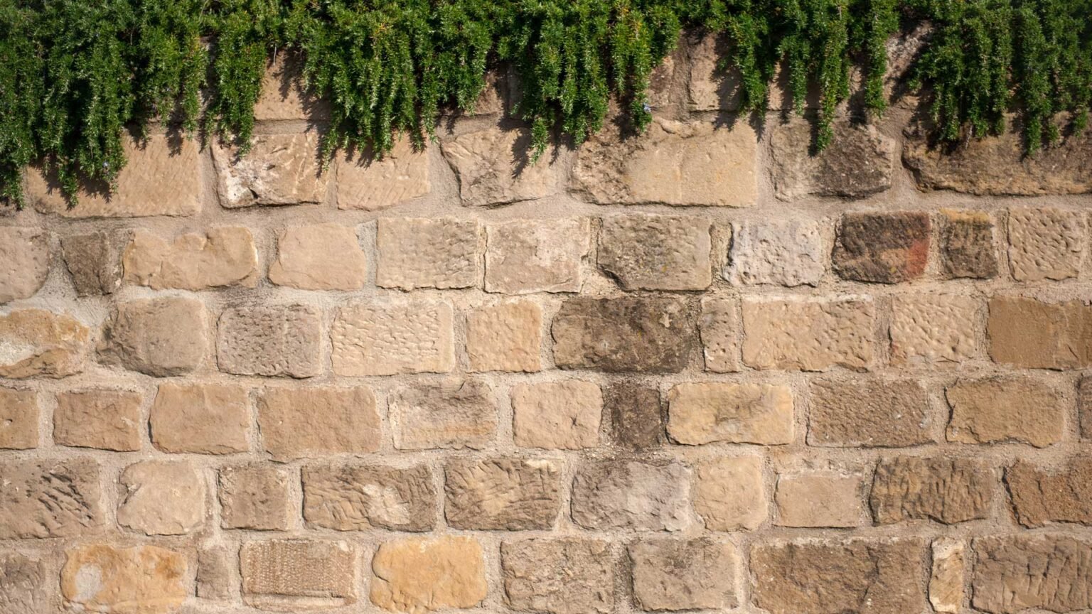 A traditional rough dressed sandstone wall with lime mortar creates a period look and feel.