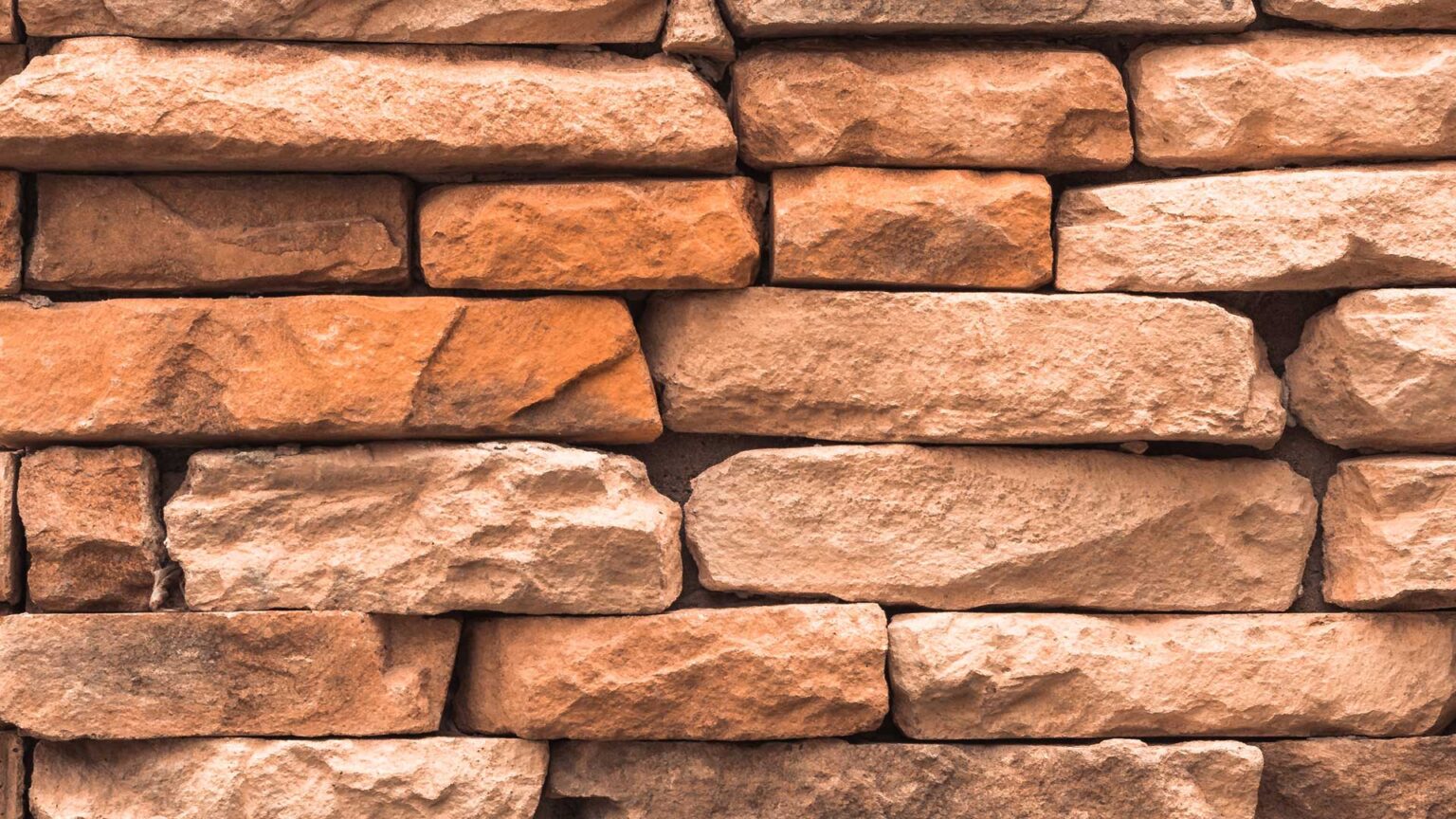 Red sandstone blocks hewn/dressed to create more uniform course heights.