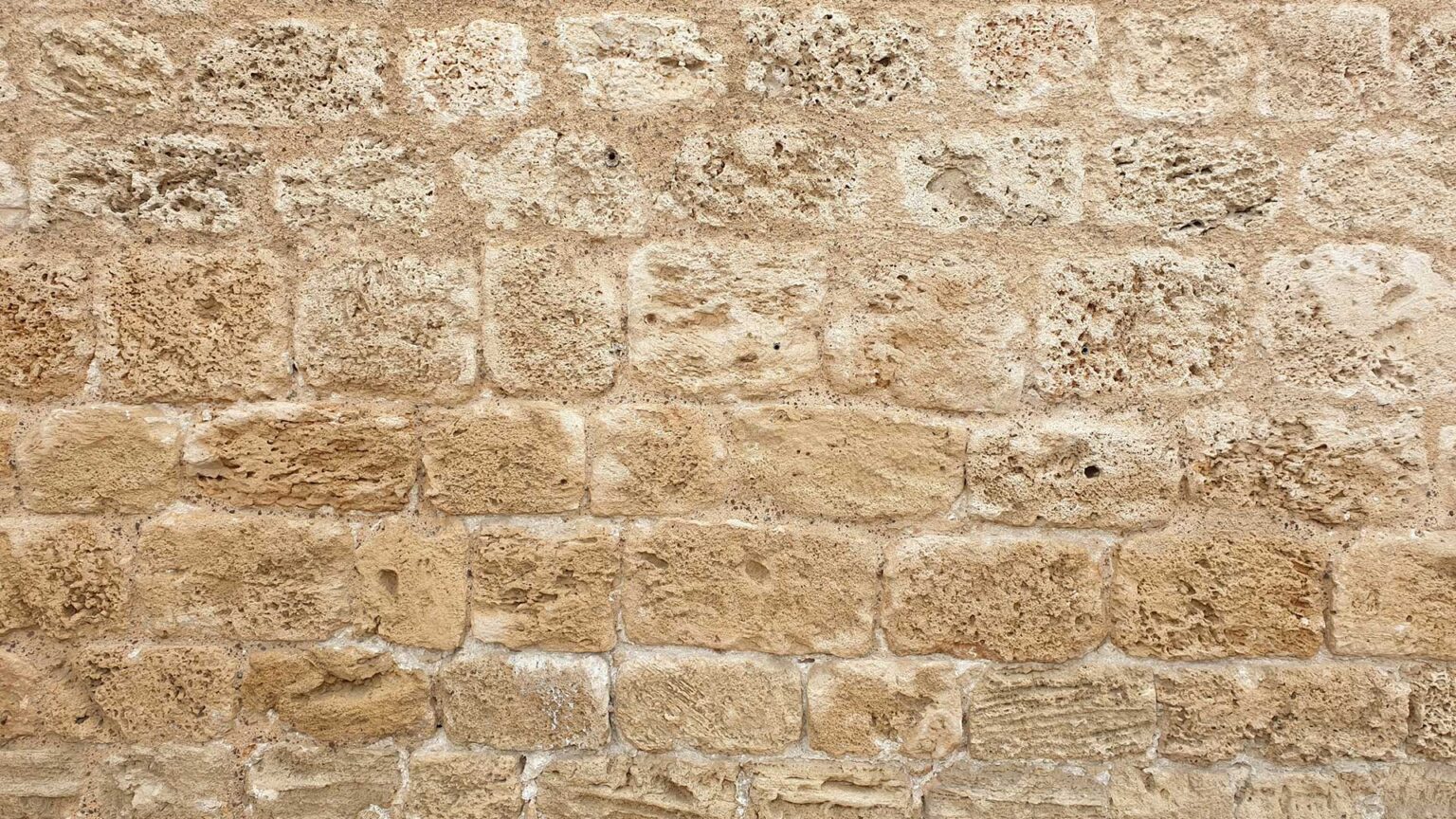 A bonded wall of limestone blocks. Notice the water/chemical erosion on the face of the blocks.