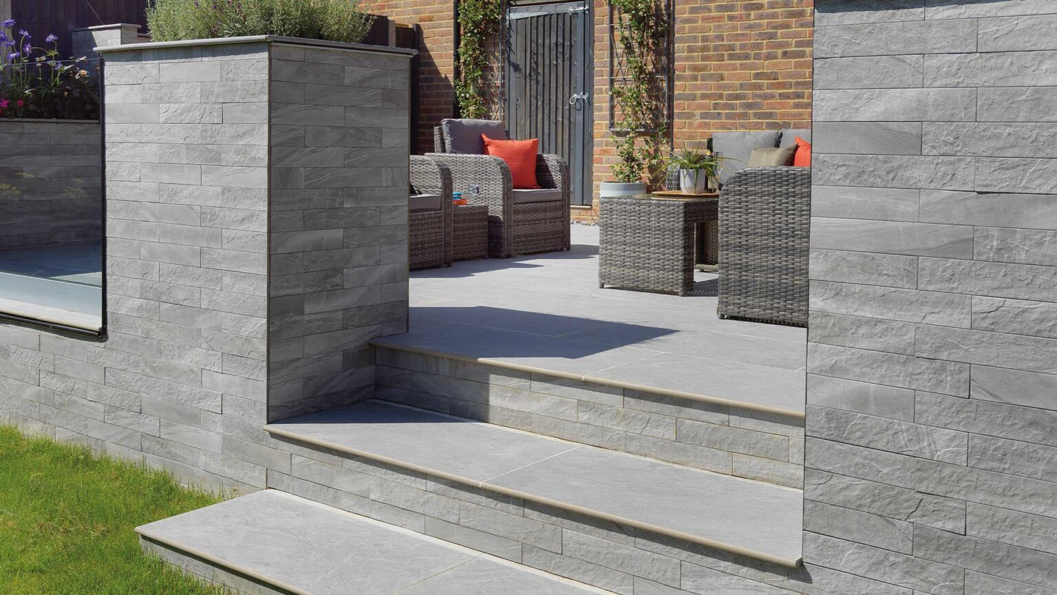 Grey porcelain steps & patio using Dolomite Moon slabs with Minerali Zinco Cladding on the walls and step risers.