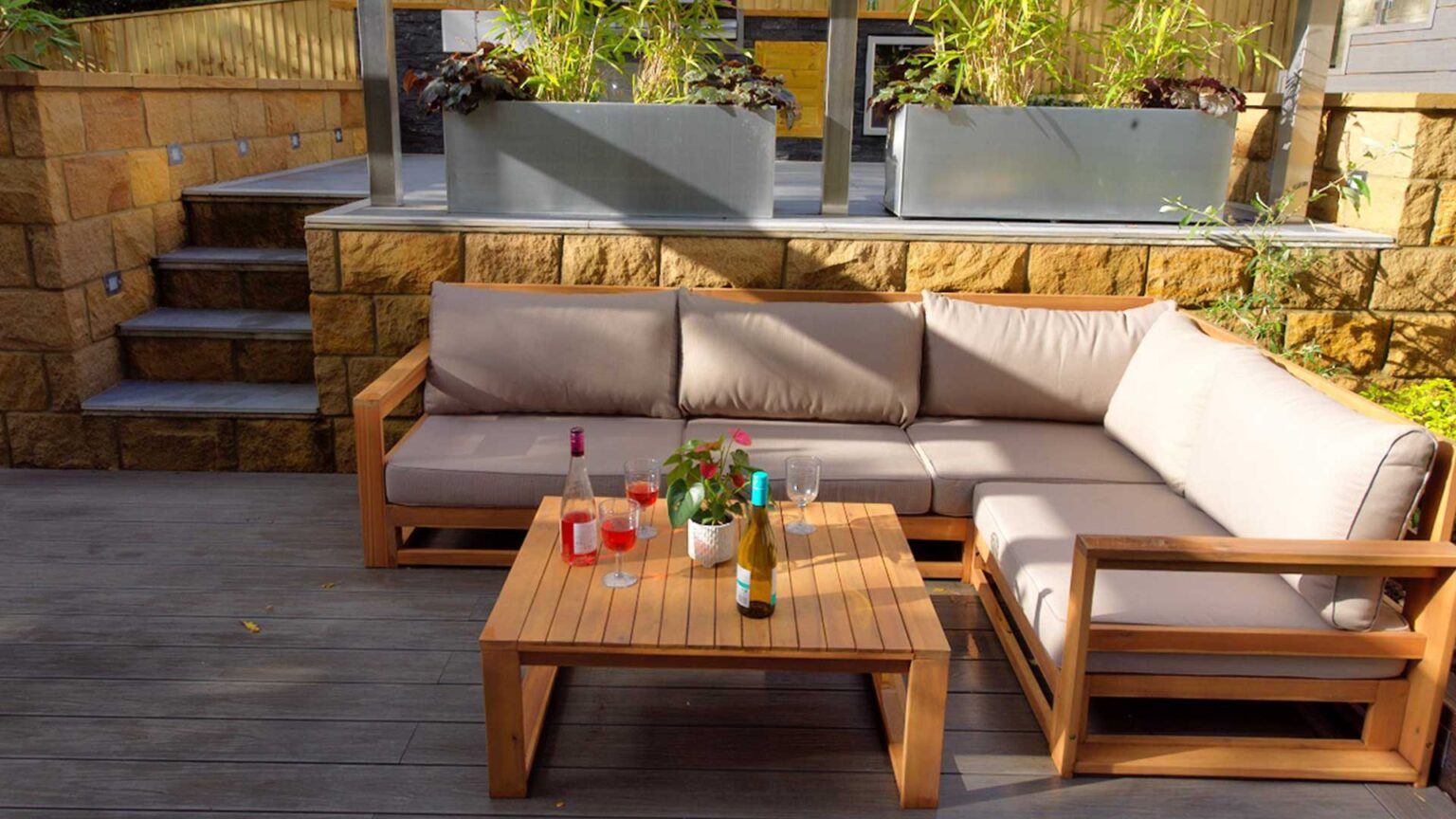 A sunken garden sofa seating area with hewn sandstone bound block walls with internal lighting units.