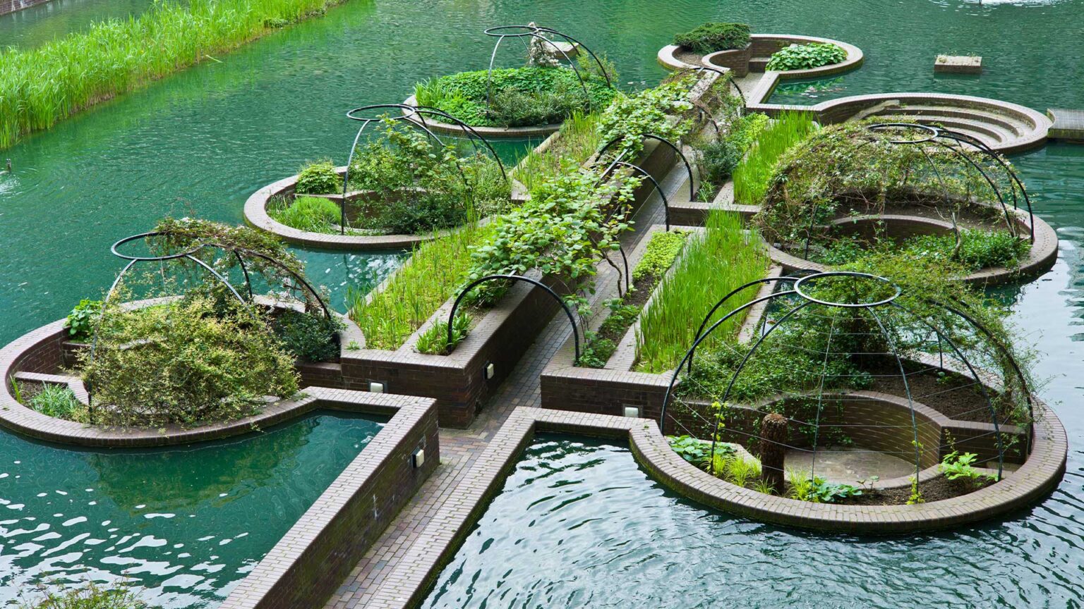 A seven-section sunken garden with raised beds and arbours set into a lake.