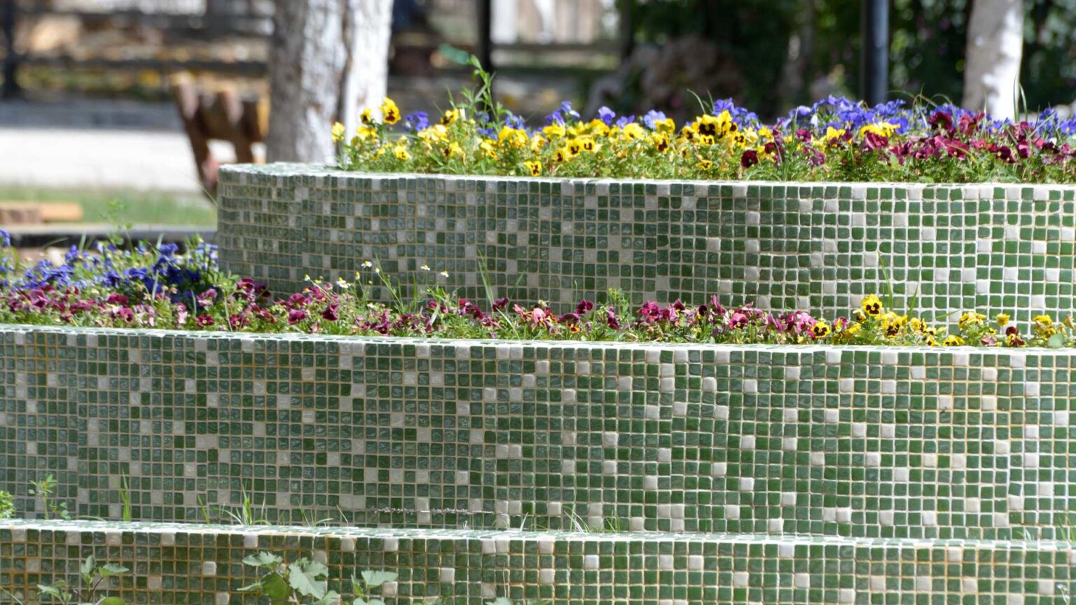 Glazed pool tiles used here on the walls of these terraced raised flower beds.