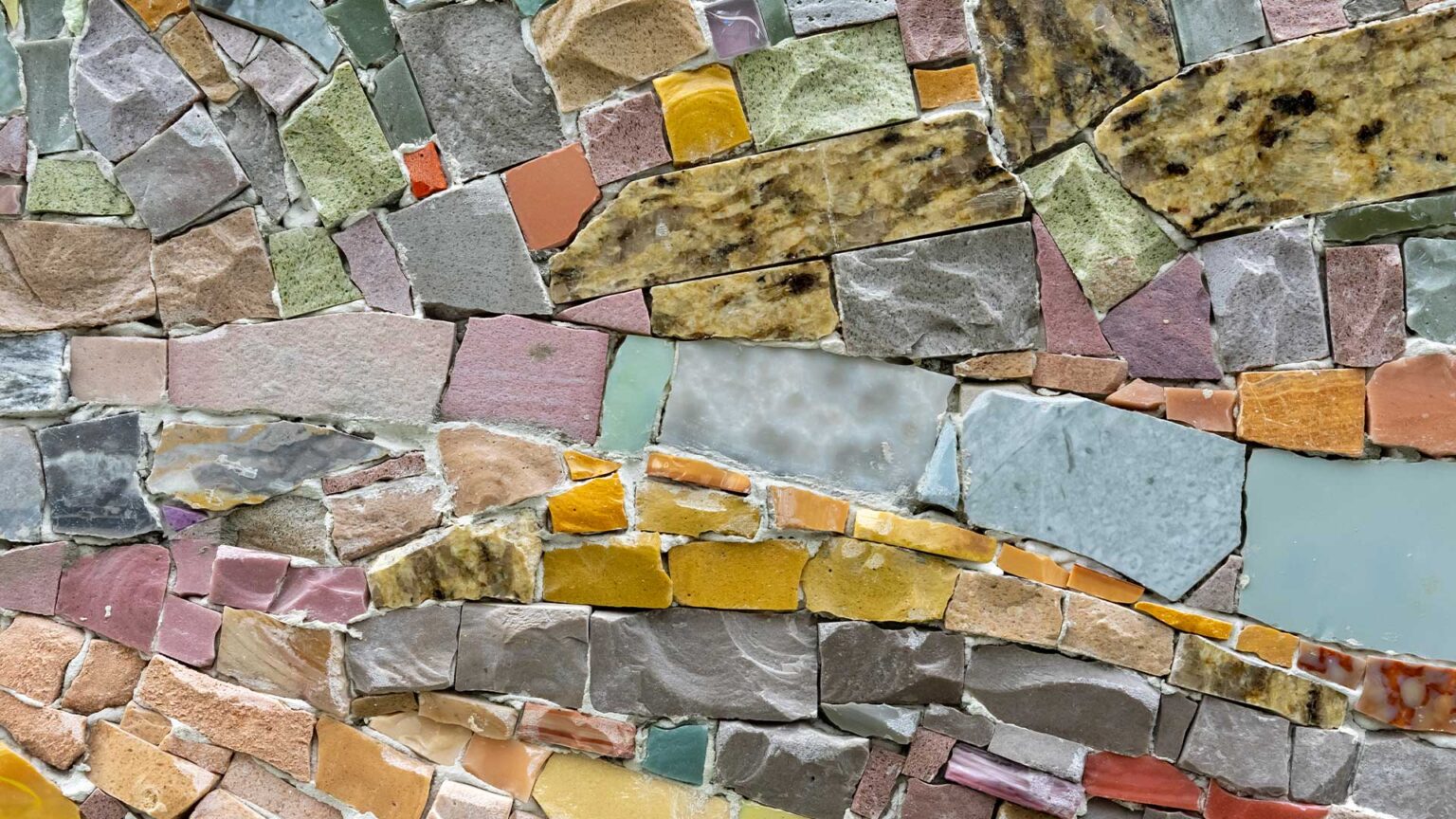 A rough mosais made up of broken masonry fragments, creating visual interest and an artisan finish to this wall.