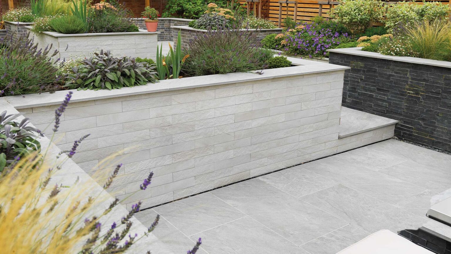 White porcelain cladding on this sunken garden's dwarf wall. Note the porcelain slabs used as coping stones.